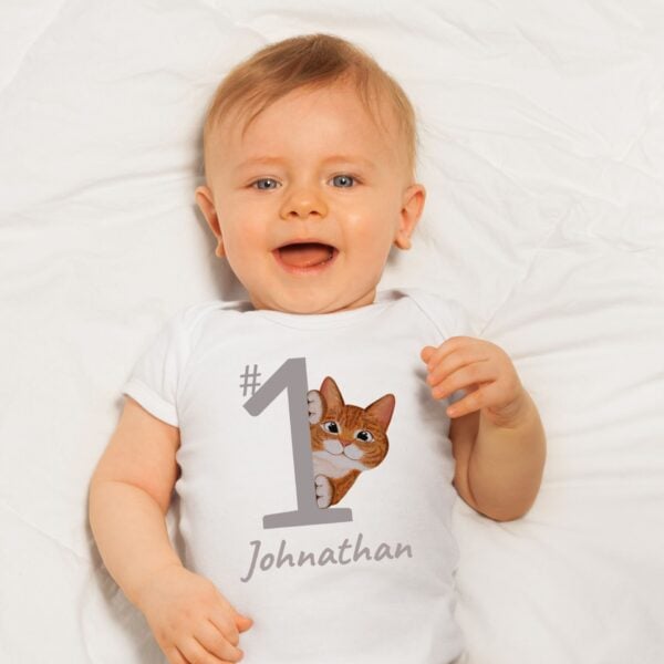 Baby wearing a white summer bodysuit with a ginger cat design and the name "Johnathan" which is optional to personalize with your baby's name.