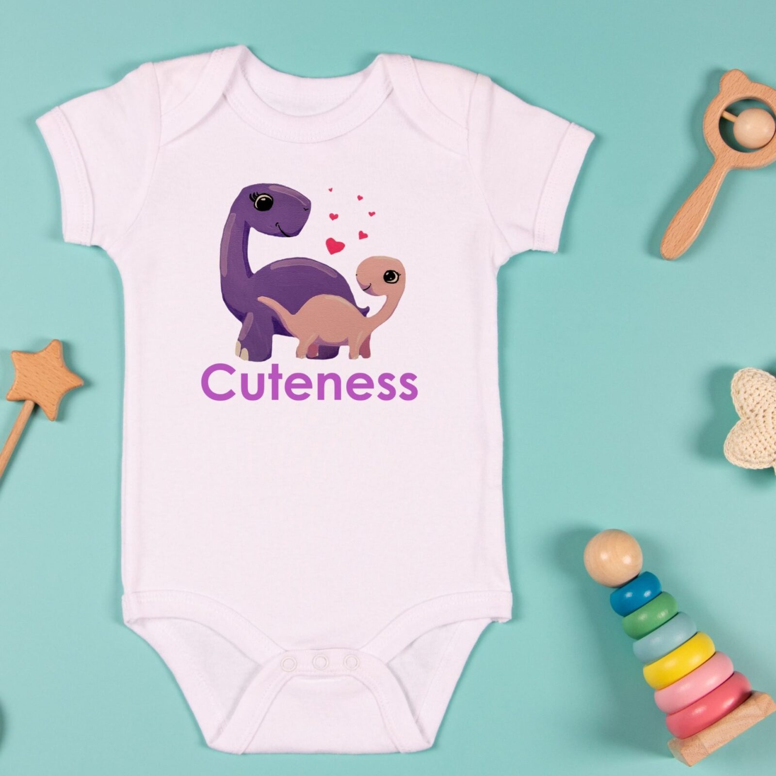 A cute Dinosaur design bodysuit with the word cuteness on it