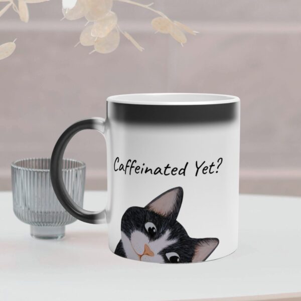 This magic mug changes colour and reveal a cat when filled with hot coffee. It has a black tuxedo cat design and text on both sides of the mug. It is optional to personalize the text.