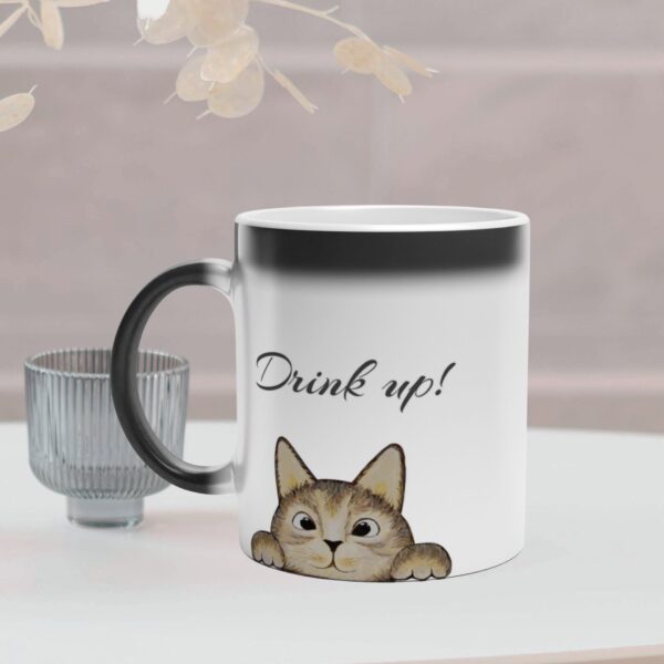 This magic mug changes colour and reveal a cat when filled with hot coffee. It has a brown cat design and text on both sides of the mug. It is optional to personalize the text.