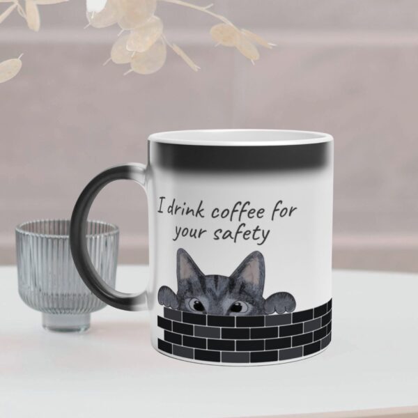 This magic mug changes colour and reveal a cat when filled with hot coffee. It has a grey cat design and text on both sides of the mug. It is optional to personalize the text.