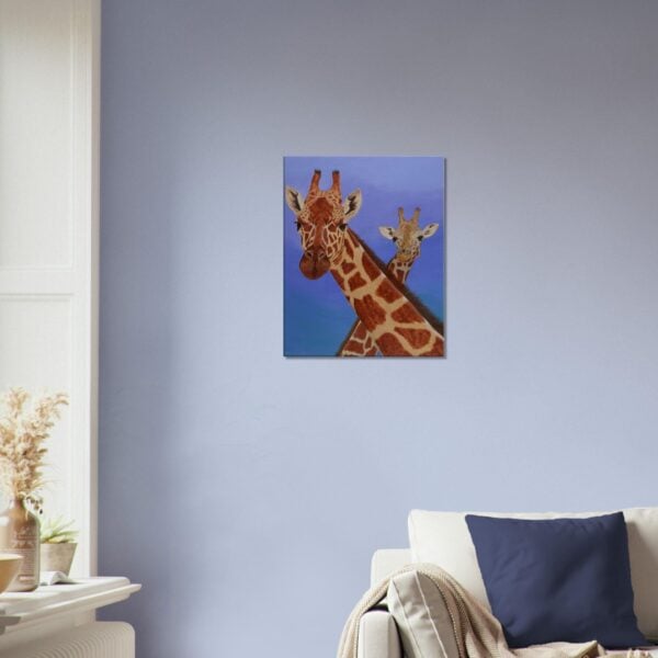 Canvas print of a mother and youngster giraffe with a blue background, hanging on a living room wall.