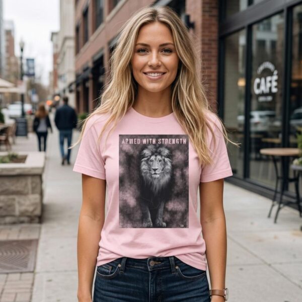 Armed with Strength Tshirt Blonde Woman A woman wearing a pink Unisex t-shirt with a Lion design. This Christian design includes the word "Armed with Strength".