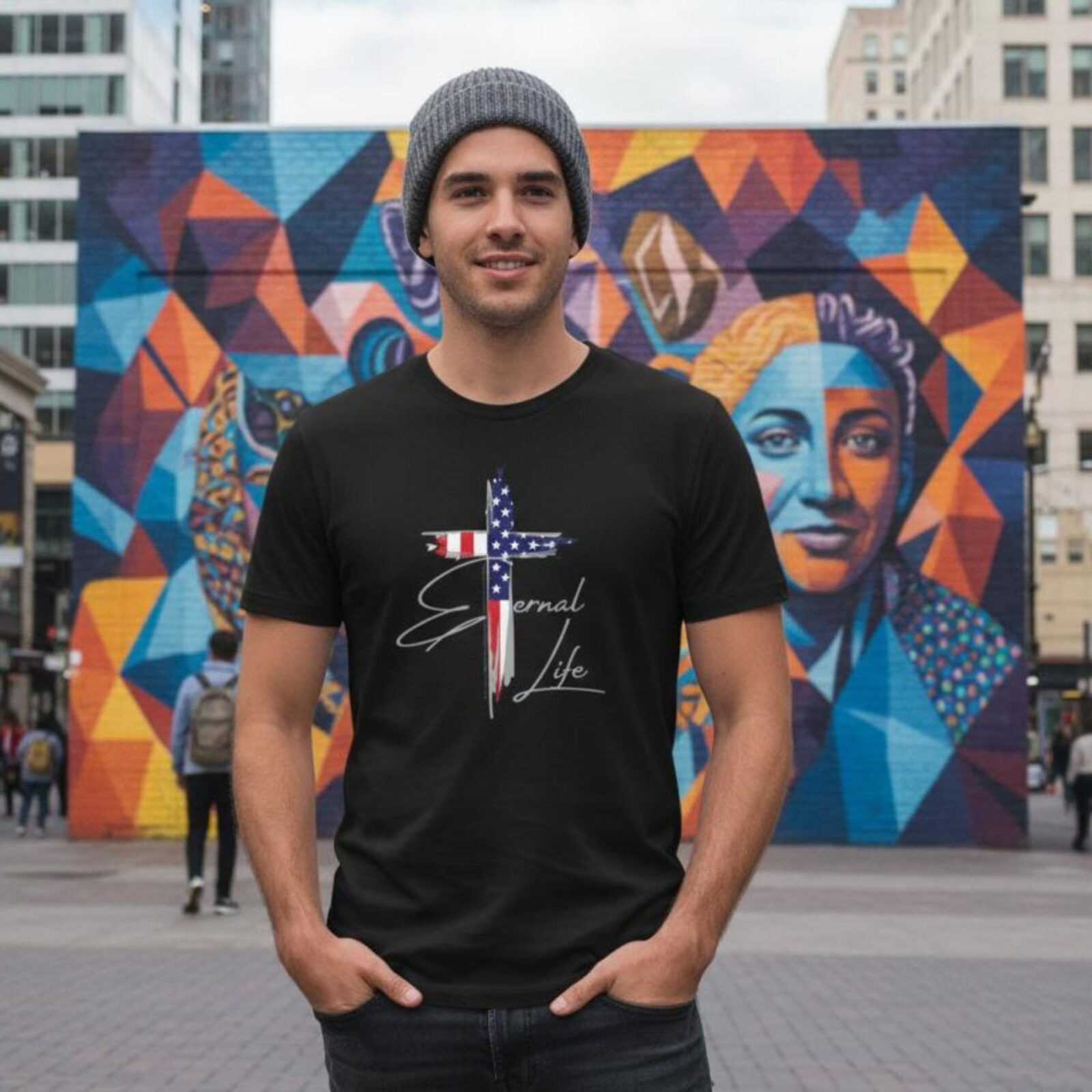 A man wearing a black unixes t-shirt with a cross design. This Christian Cross design with the USA flag includes the text "Eternal Life" and quote Galatians 3:11.