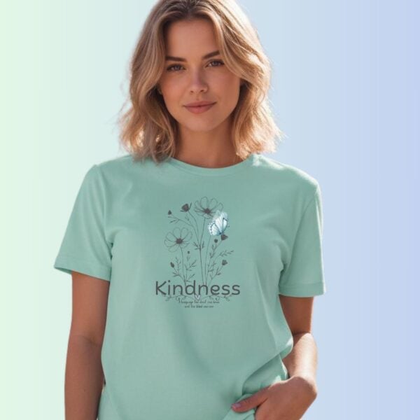 A woman wearing a mint coloured t-shirt with a flower and butterfly design, and the text "Kindness" and "A language the deaf can hear and the blind can see".