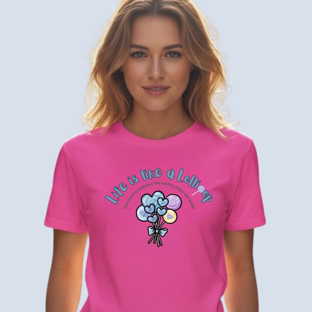 A woman wearing a charity pink coloured t-shirt with a lollipop design, the text "Life is like a Lollipop" and "you have to embrace the hard to enjoy the sweet".