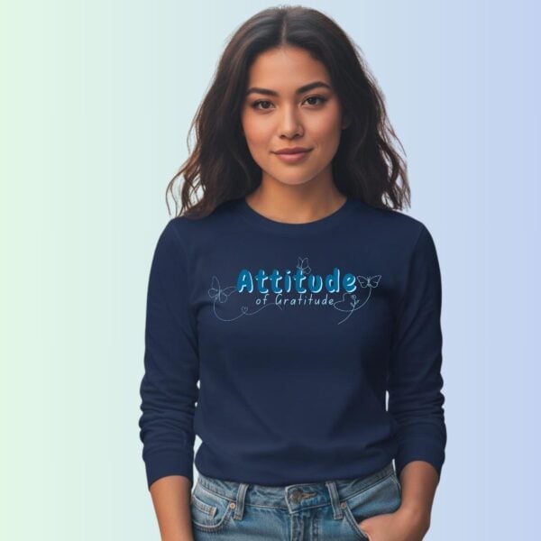 A woman wearing a navy coloured long sleeve t-shirt with a butterfly design and the text "Attitude of Gratitude".