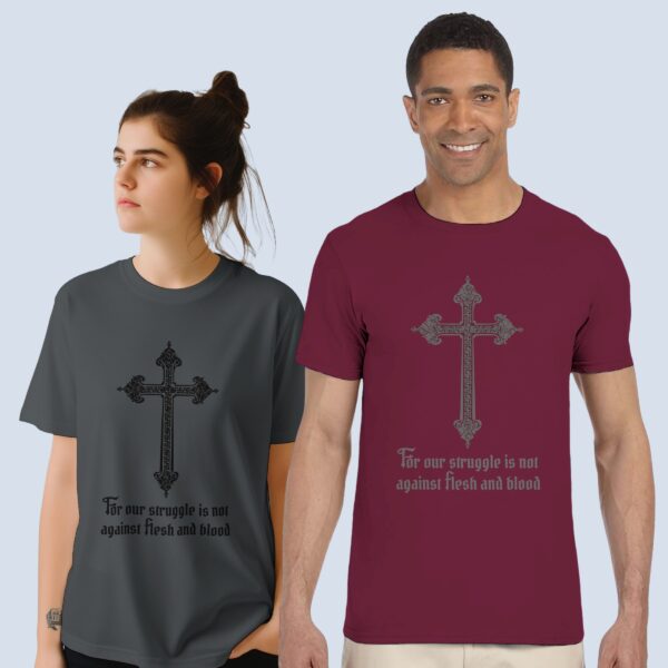 A man wearing a maroon unisex t-shirt and a woman wearing a charcoal unisex t-shirt, both with a cross design and the text "For our struggle is not against flesh and blood".