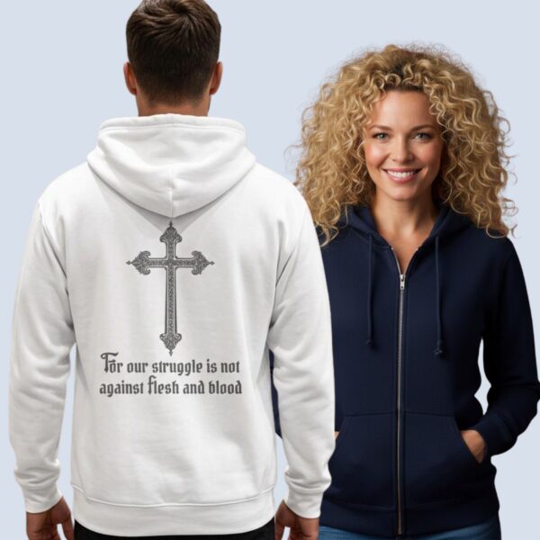 A man wearing a white unisex zipper hoodie with a cross design and the text "For our struggle is not against flesh and blood" on the back of the hoodie, and a woman wearing a navy coloured zip hoodie with the same design on the back.