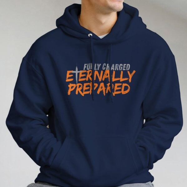 A man wearing a navy unisex pullover hoodie with a cross and the text "Fully Charged, Eternally Prepared".