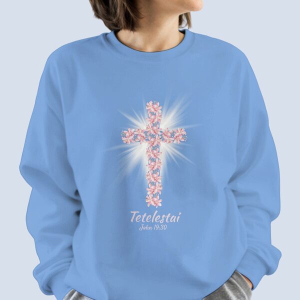 A woman wearing the sweatshirt with lily cross design and the text "Tetelestai, John 19:30" on the front of the sweatshirt.