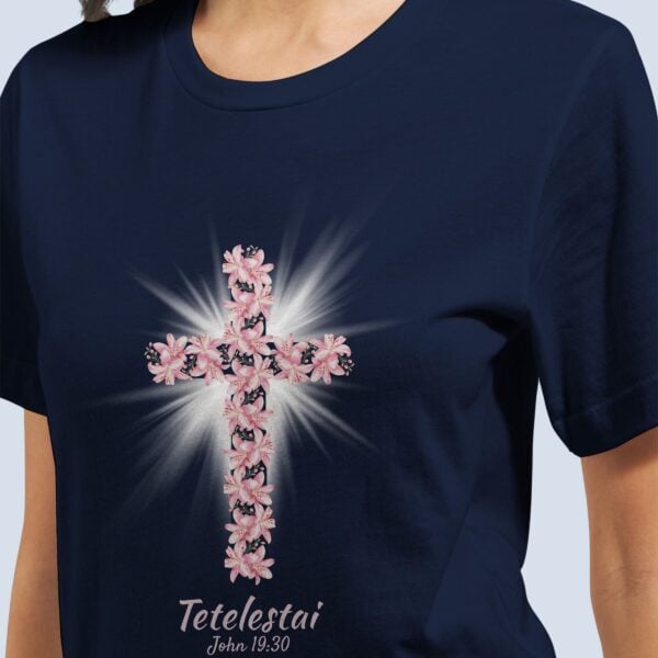 A woman wearing a navy t-shirt with a lily cross design and the text "Tetelestai, John 19:30".