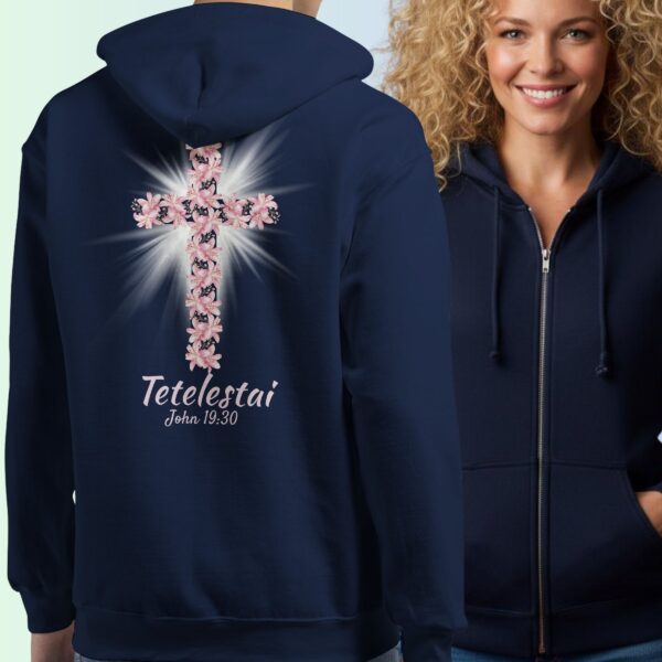 Women wearing a navy zipper hoodie with a cross and lily design with the text "Tetelestai, John 19:30" on the back.