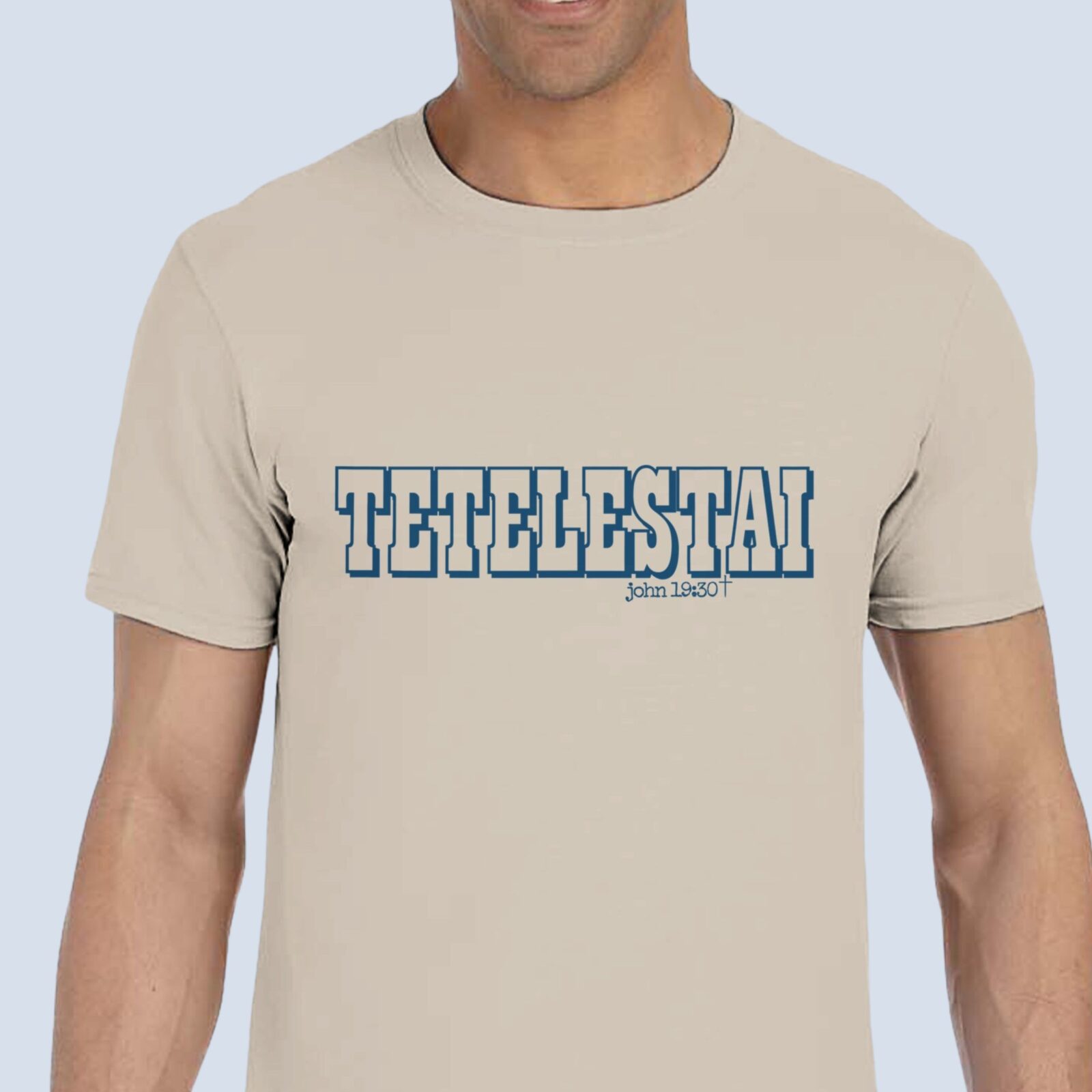 A man wearing a sand coloured unisex t-shirt with the text "Tetelestai, John 19:30".