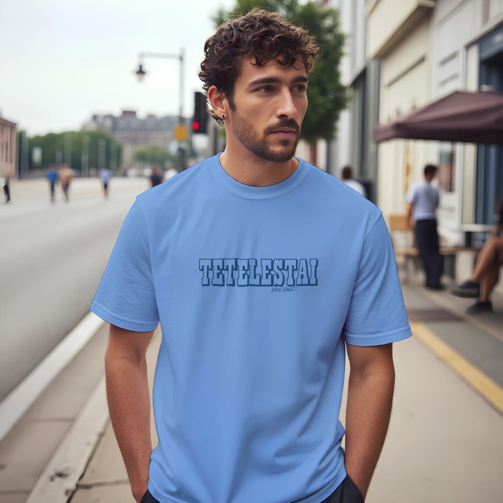 A man wearing a Carolina blue unisex t-shirt with the text "Tetelestai, John 19:30".