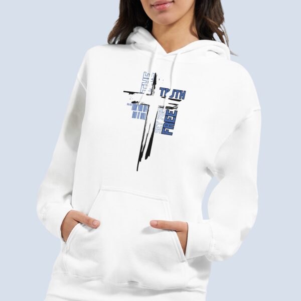 A woman wearing a white unisex pullover hoodie with a cross design and the text "The Truth may tick you off, but it Will Set You Free".
