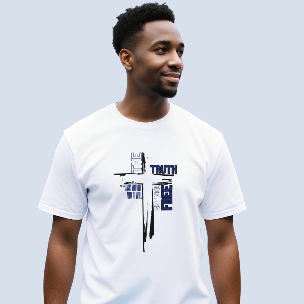 A man wearing a white t-shirt with a cross design and the text "The truth may tick you off but it will set you free".