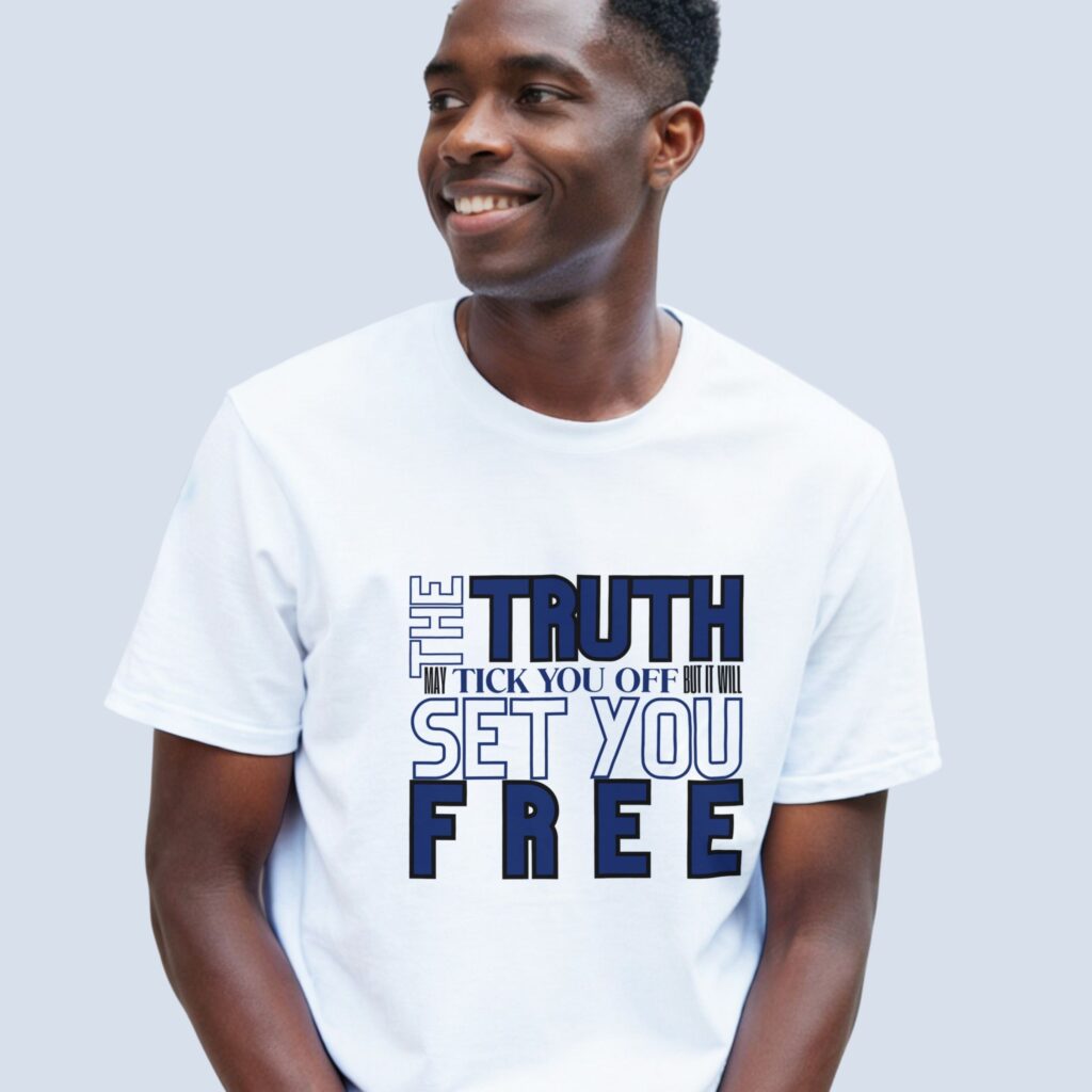 A man wearing a white unisex t-shirt with the text "The Truth may tick you off, but it Will Set You Free".