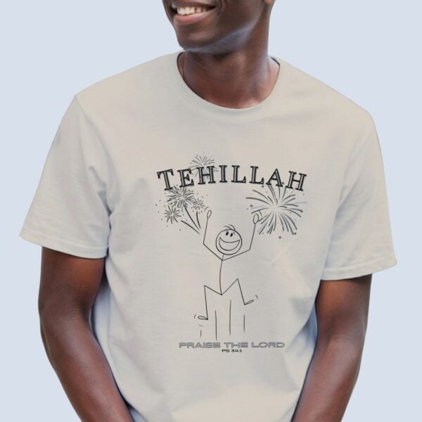 A man wearing a sand coloured unisex Christian t-shirt with a playful stick figure and celebratory fireworks design featuring the Greek word Tehillah, meaning praise, alongside “Praise the Lord” and Psalm 34:1. The design is printed on the front of the t-shirt only.
