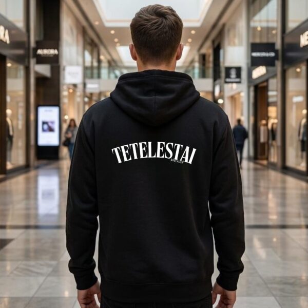 A man wearing a navy unisex zipper hoodie with the text "Tetelestai" and "John 19:30" printed on the back.