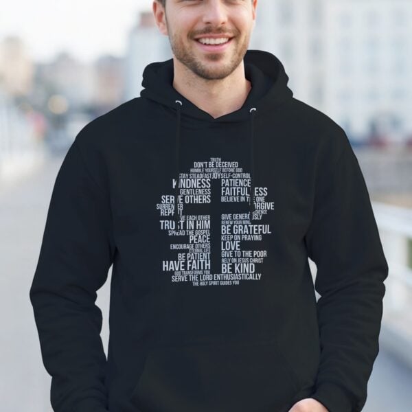 Word Cross Pullover Hoodie Man Walking A man wearing a black unisex pullover hoodie with a cross surrounded by uplifting Christian phrases including Be Kind, Surrender, Trust in Him, and Give to the Poor, printed on the front.