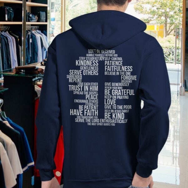 Word Cross Zip Hoodie Man Store A man wearing a navy unisex full zip up hoodie with a cross cross surrounded by uplifting Christian phrases including Be Kind, Surrender, Trust in Him, and Give to the Poor, printed on the back.