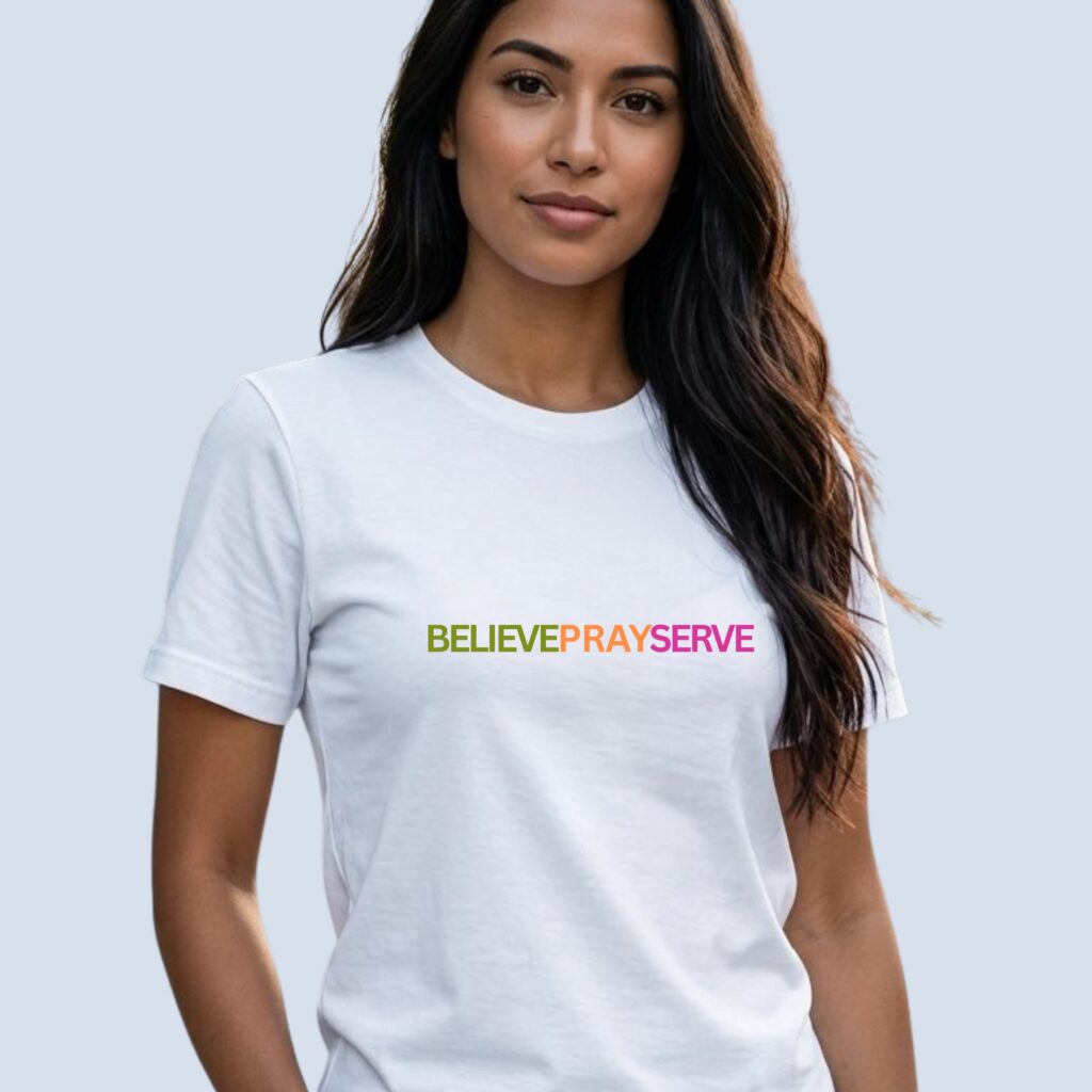 A woman wearing a white unisex Christian t-shirt featuring the powerful words “Believe Pray Serve”, printed on the front of the t-shirt. It is a soft faith-based tee with inspirational design perfect for church, gifts, and everyday wear.