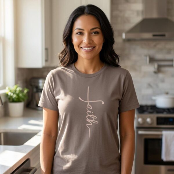 A woman wearing a pebble brown Christian t-shirt with the word faith, written in such a way to form a cross. This faith cross shirt for women is a minimalist Christian tee design that comes in 11 colour options.