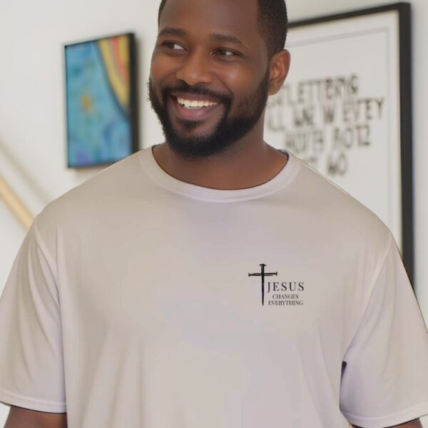 Jesus Changes Everything Tshirt Man Close up A close-up of a man wearing the sand coloured unisex Christian t-shirt featuring a three nail cross and the powerful words “Jesus Changes Everything", printed on the front left side of the t-shirt.