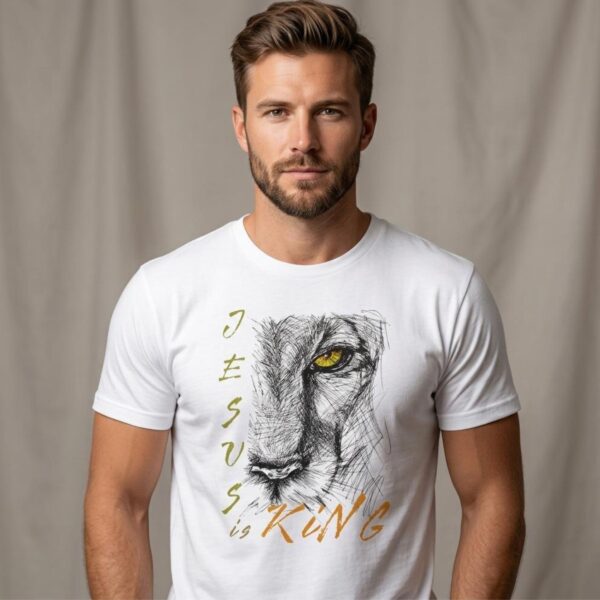 A man wearing a white Christian unisex t-shirt featuring a modern lion illustration, paired with the text: "Jesus Is King", inspired by Revelation 19:16.